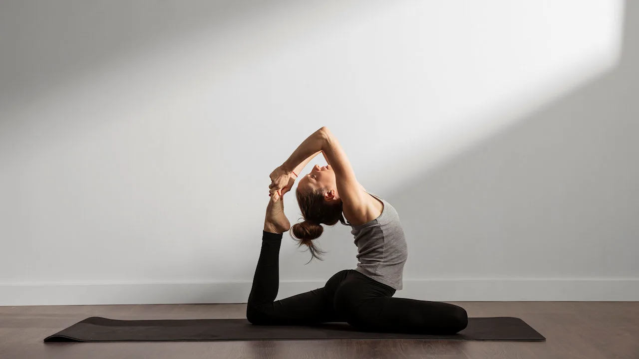 Femme pratiquant le yoga en posture du pigeon relevé