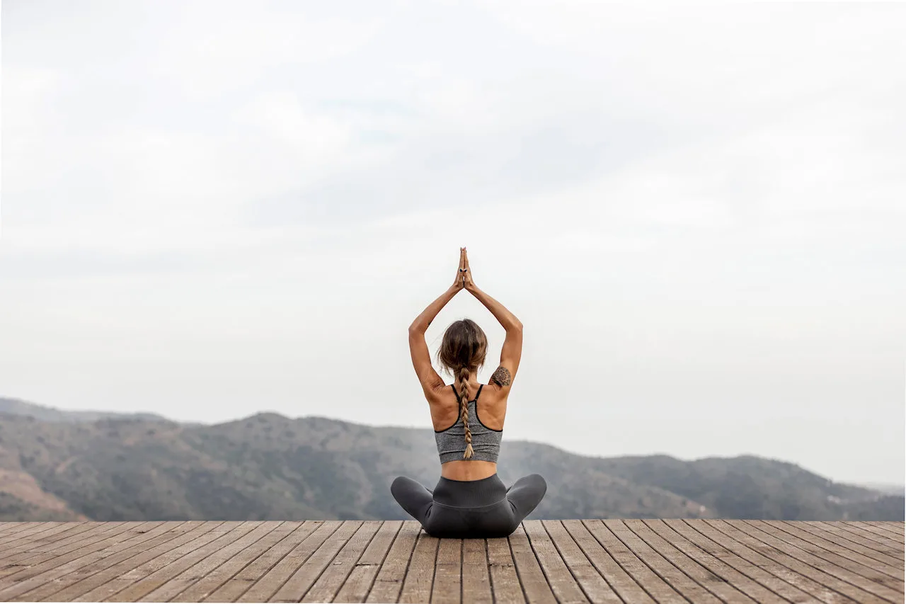 Femme pratiquant le yoga en extérieur, posture lotus mudra
