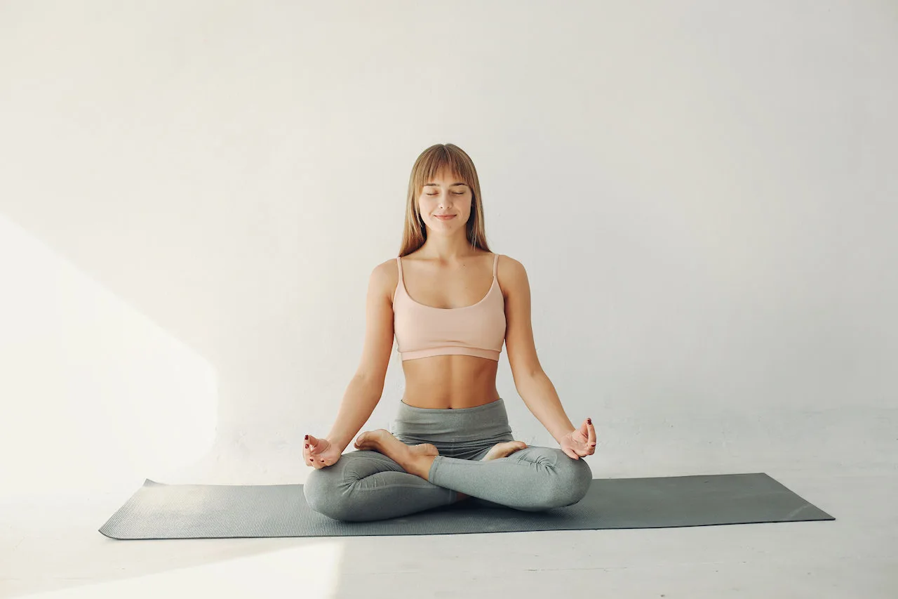 Femme pratiquant le yoga en studio, position du lotus